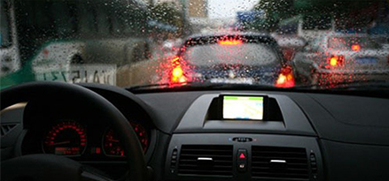 view of rain from the front of a car in traffic