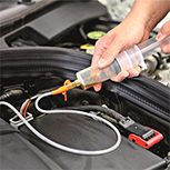 man siphoning oil from engine