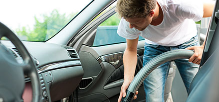 man vacuuming passenger seat shutterstock