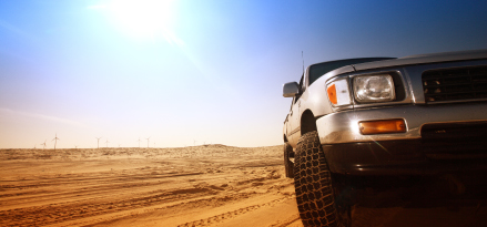 vehicle running in the desert under the sun